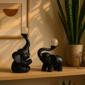 Dy elefantë njeri ulur tjetri në këmbë me top kristali