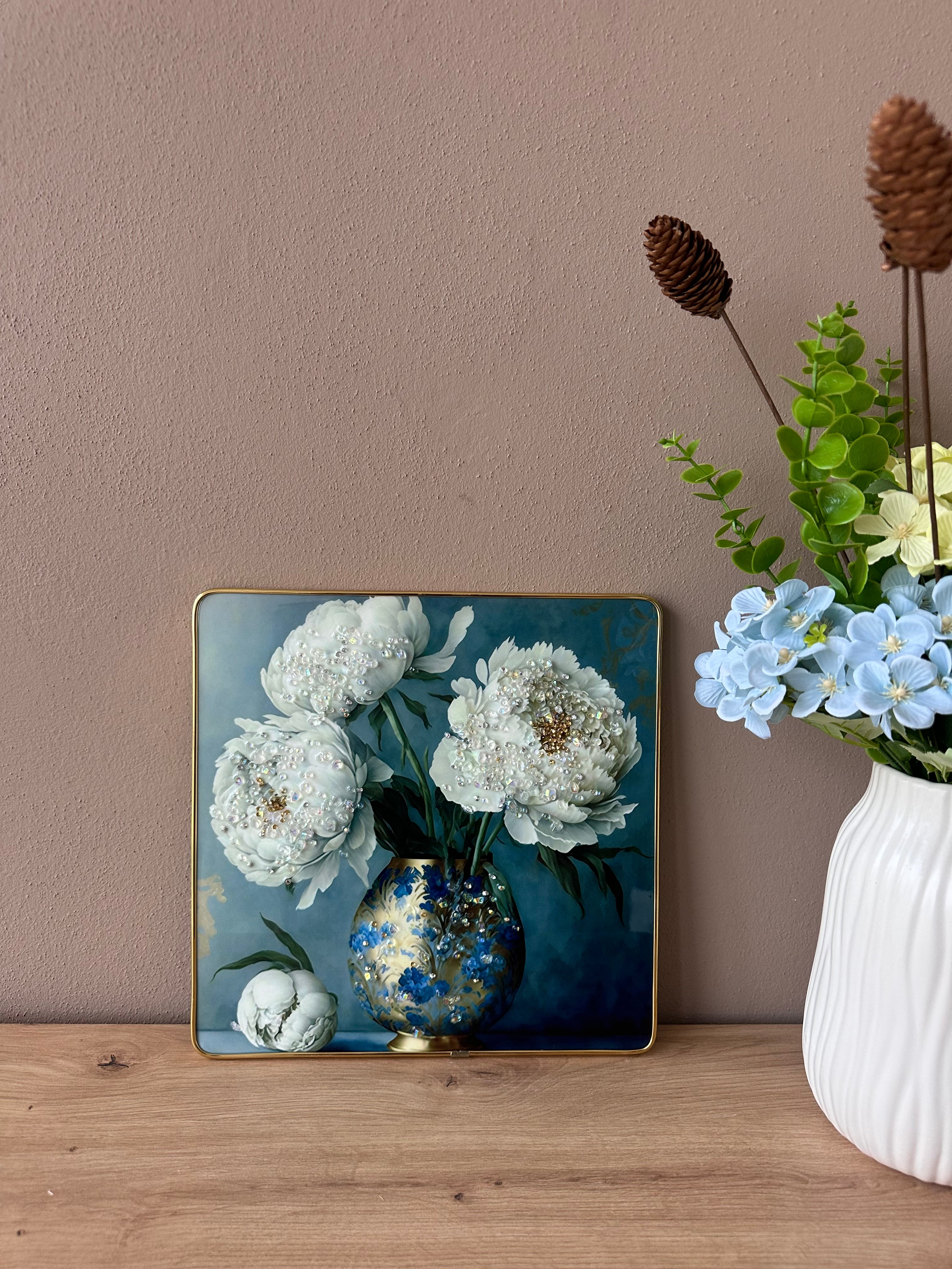 Pikturë me vazo blu dhe lule të bardha me gura zbukurues