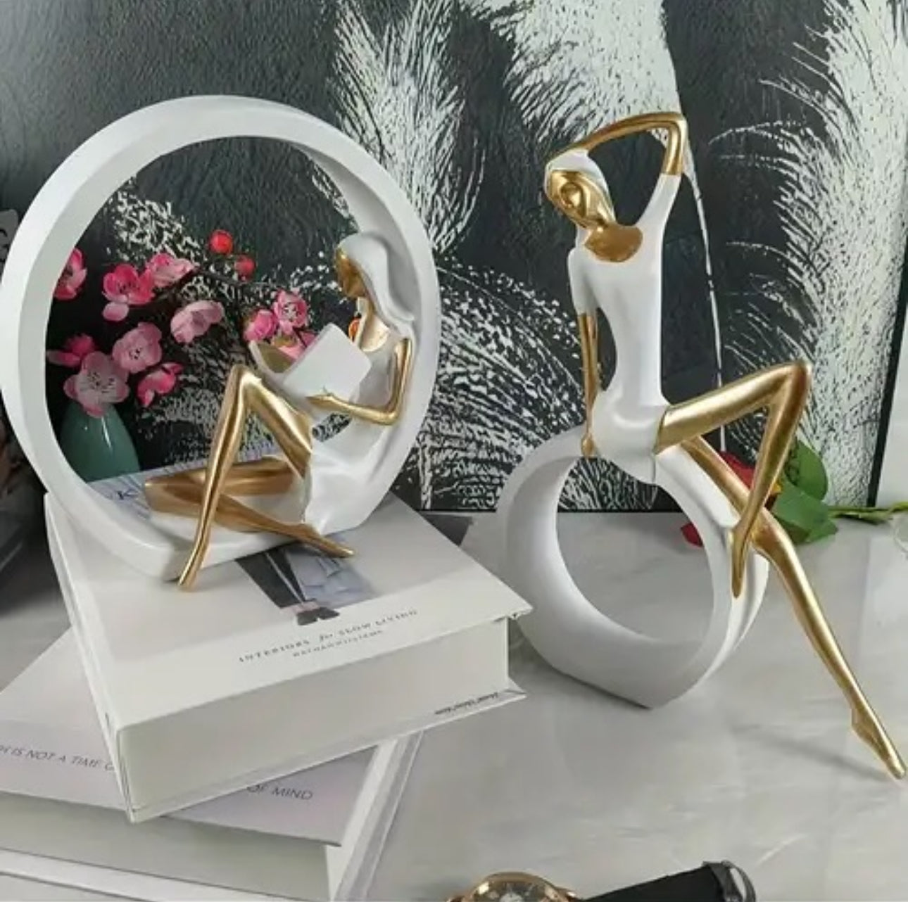 Statujë vajze që lexon libër me forma gjeometrike