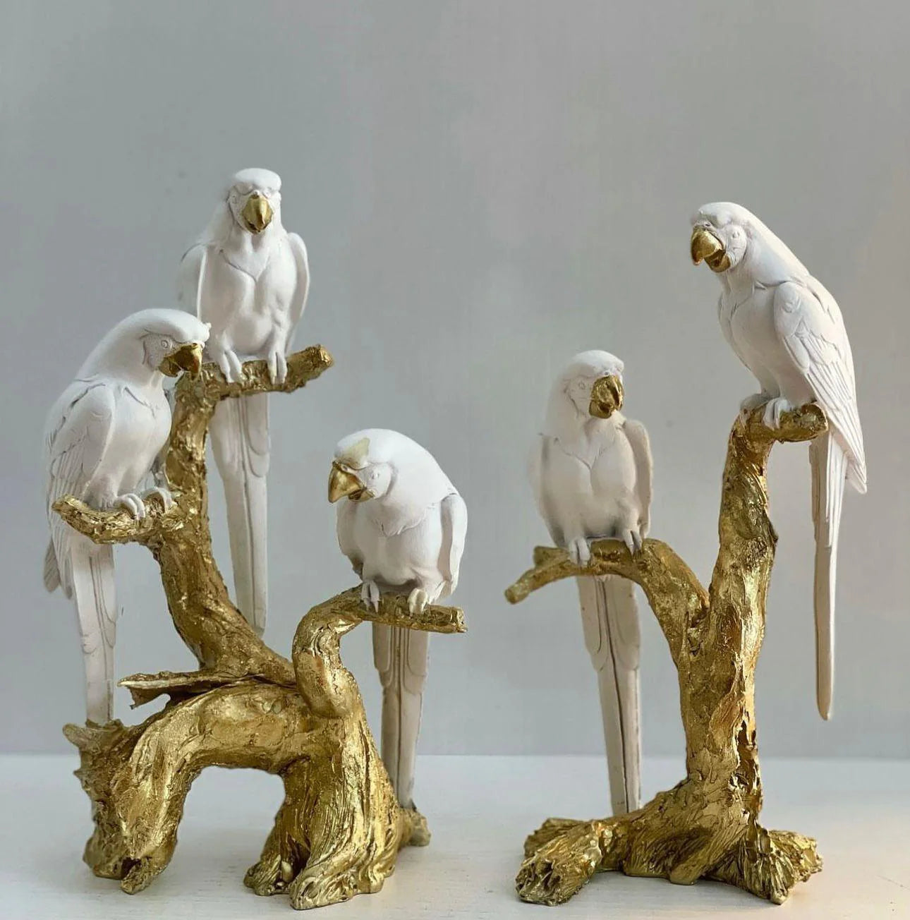 Statujë me papagaj të bardhë dhe trung druri gold