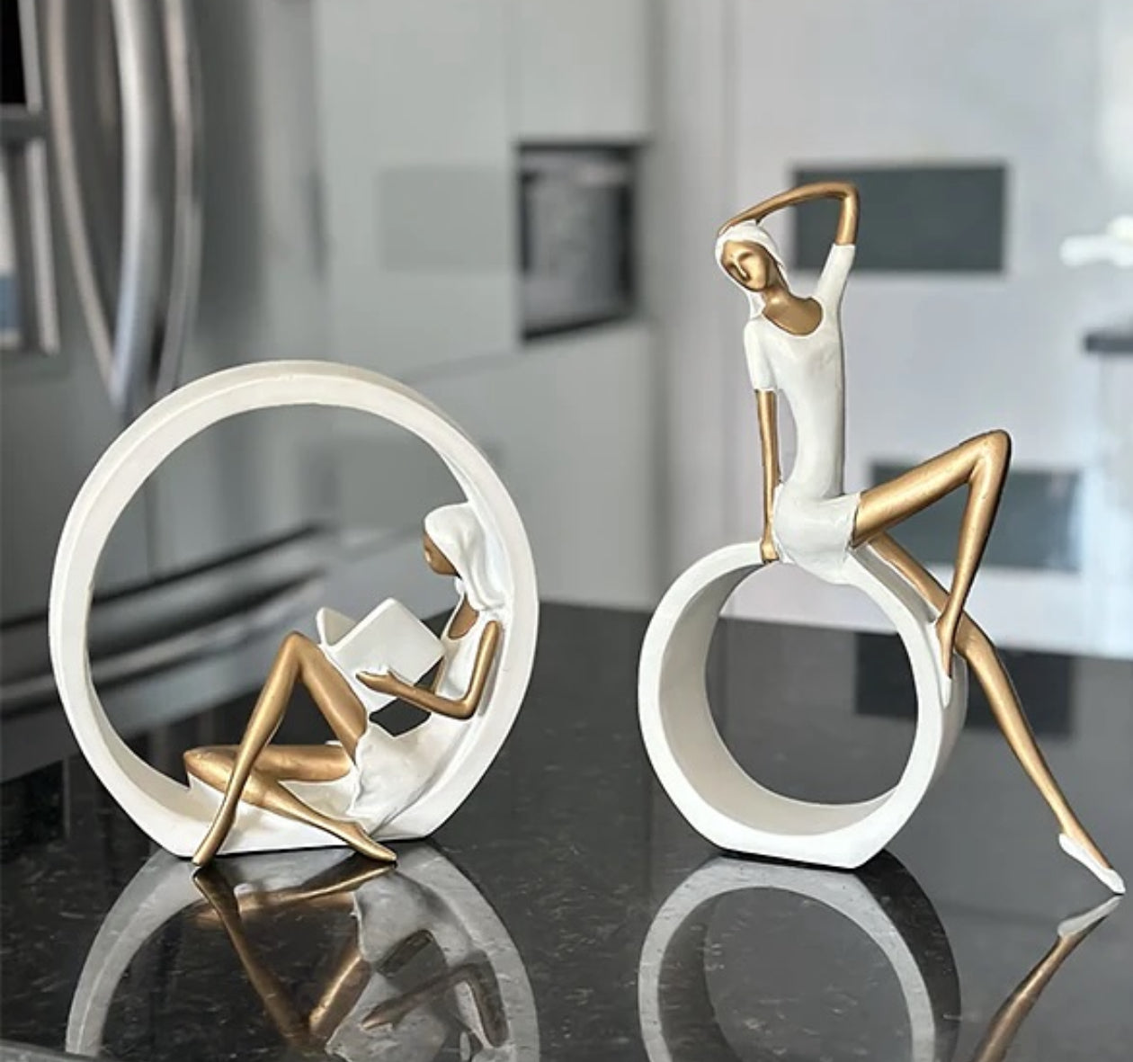 Statujë vajze që lexon libër me forma gjeometrike