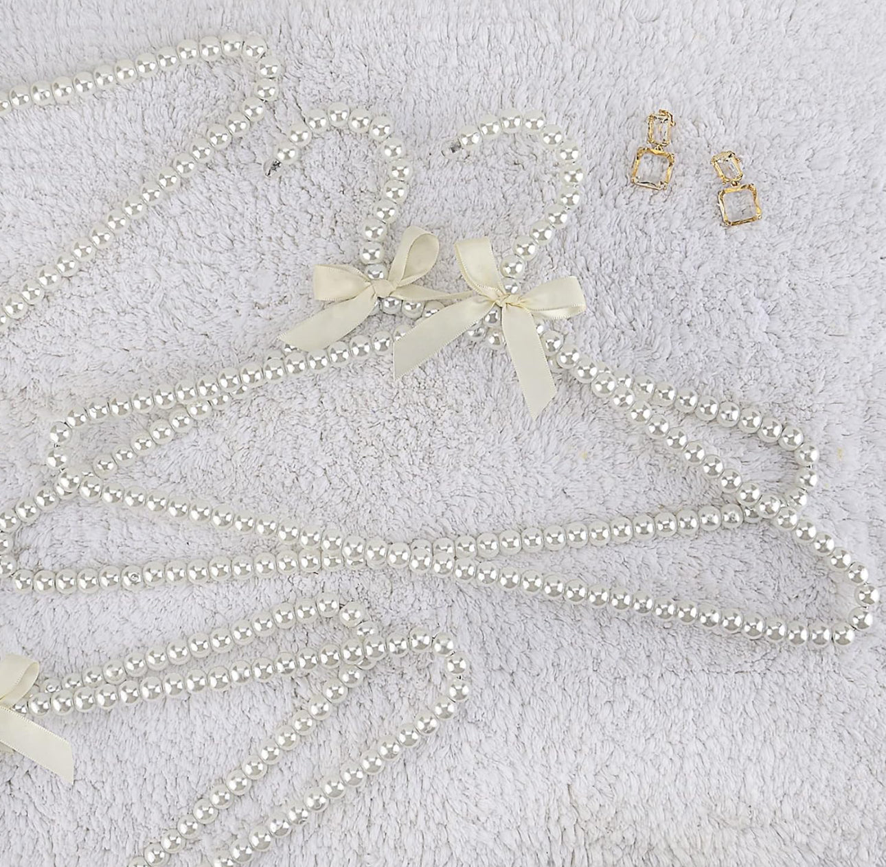 Set me 2 varëse rrobash me perla e fjongo