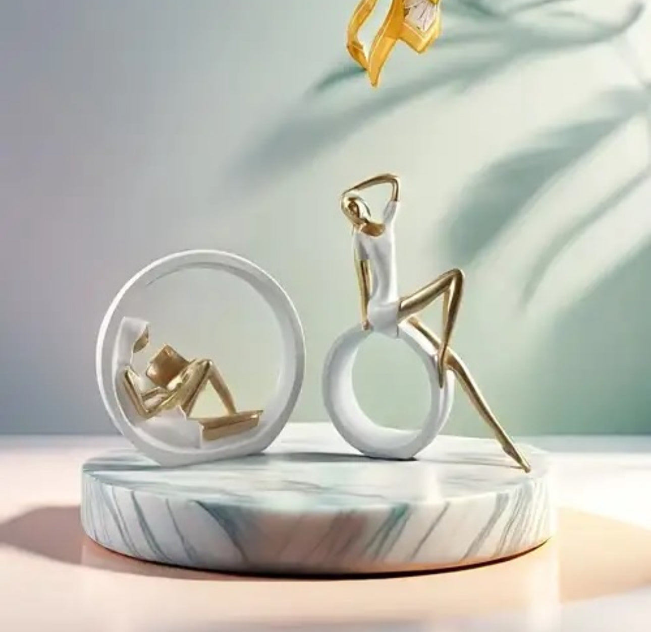 Statujë vajze që lexon libër me forma gjeometrike