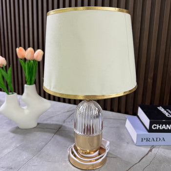 Llambë tavoline me bazë xhami formë cilindrike dhe abazhur cilindrik tekstili me detaje gold