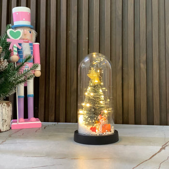 Kupolë qelqi me pemë festive dhe drer portokalli