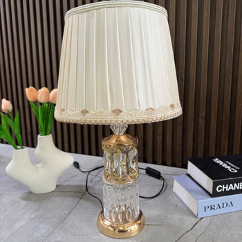 Llambë tavoline me bazë metalike dhe xhami formë cilindrike dhe abazhur konik të palosur