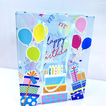 Çantë paketimi transparente "Happy birthday" me dhurata, tortë dhe tullumbace